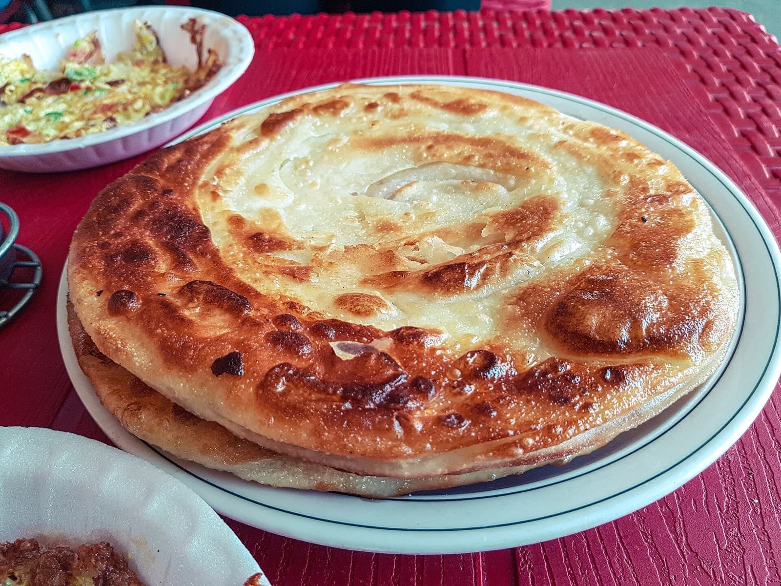 A flaky layered paratha served on a plate at a Dehradun eatery