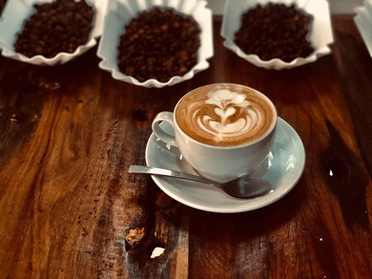 A cappuccino with latte art on a wooden café table