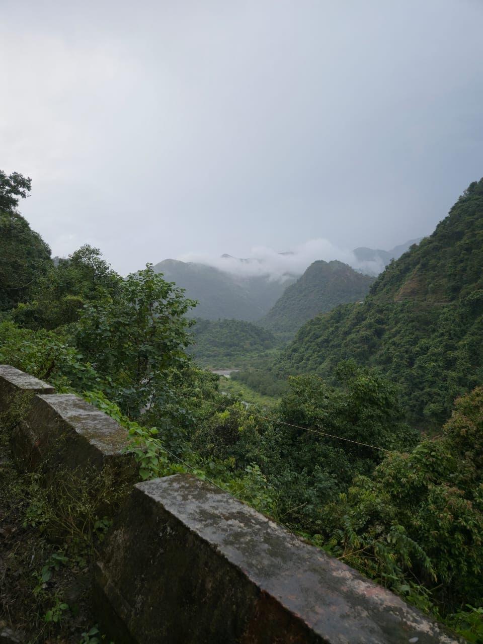 Green Himalayan foothills above the Doon valley under a soft sky