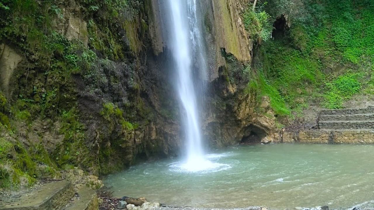 Tiger Falls near Chakrata dropping down a mossy rock face into a green pool