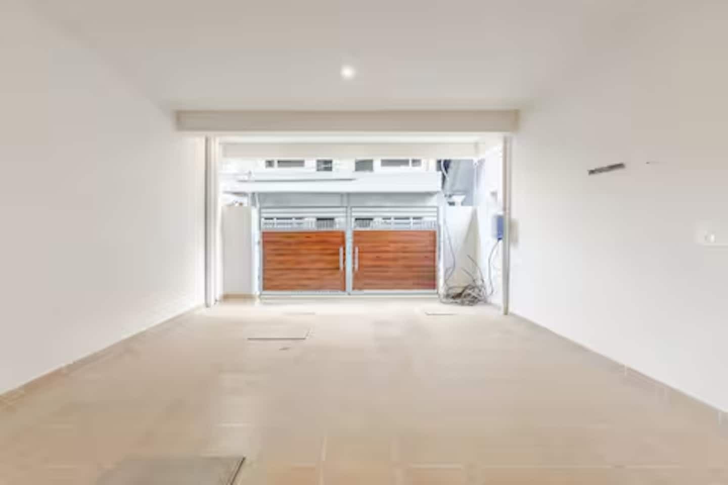 Boho by Starfish: Empty covered parking area at ground level facing a wooden front gate