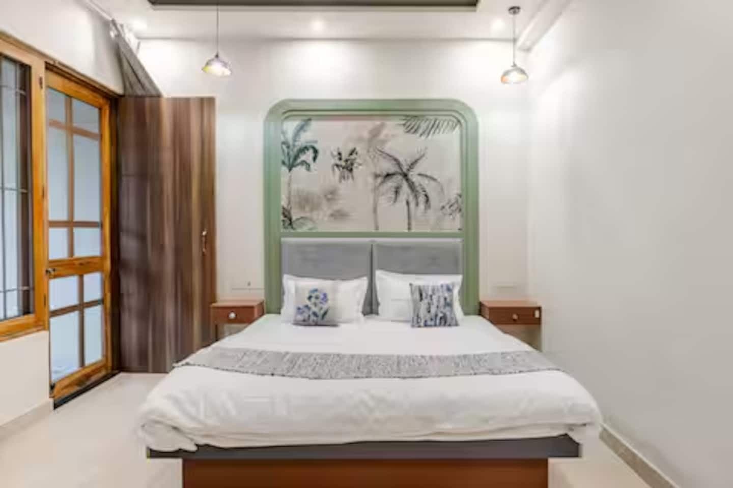 Boho by Starfish: Bedroom with palm print headboard, pendant lights and wooden framed glass door