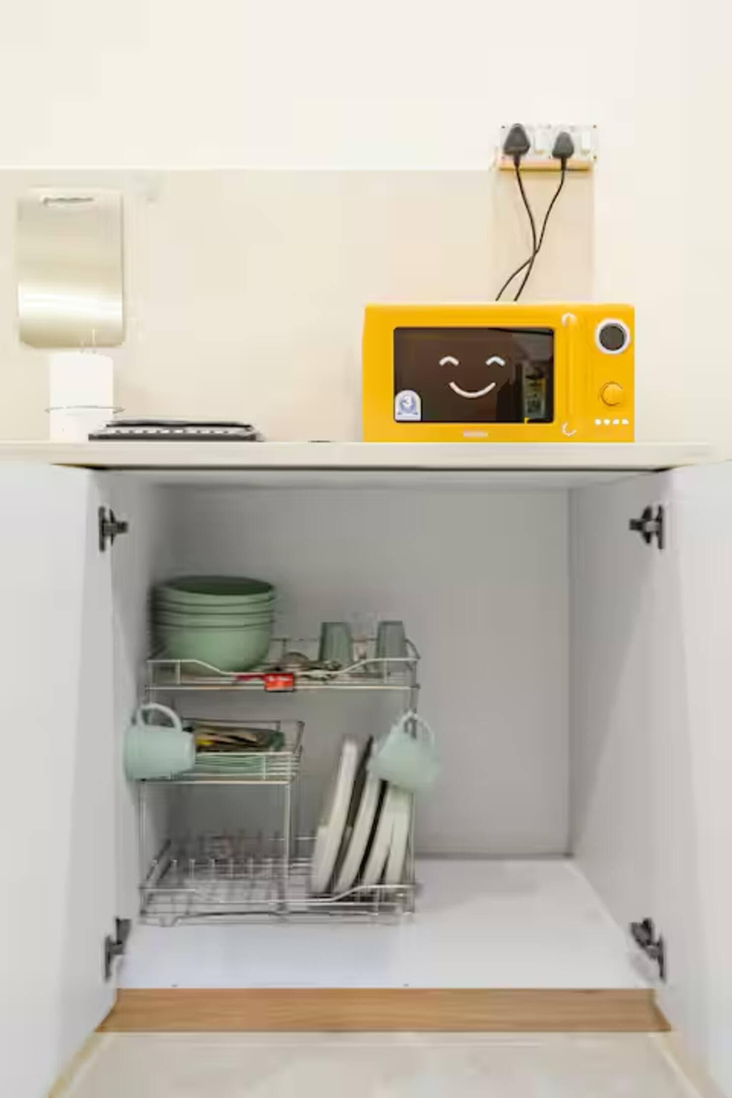 Boho by Starfish: Yellow microwave above an open cupboard with dish rack and crockery