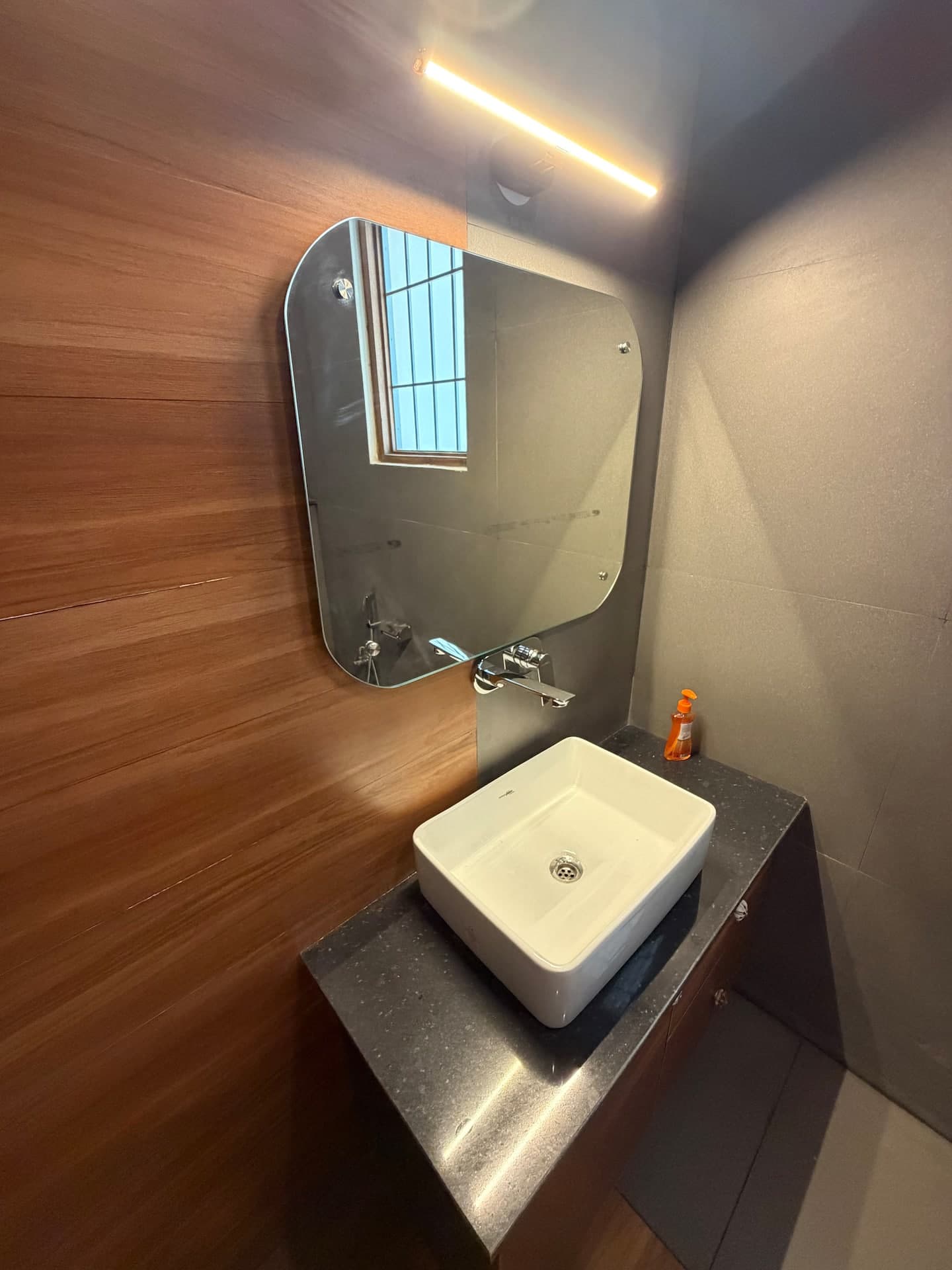 Boho by Starfish: Square vessel basin with rounded mirror and strip light on a wood-look wall