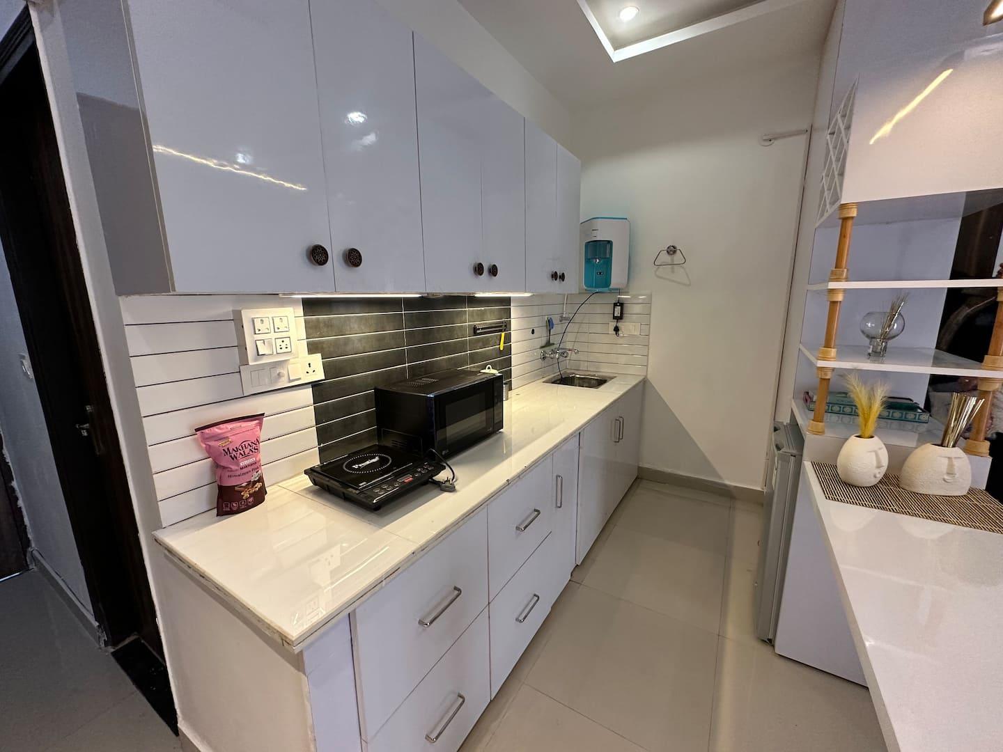 A fully-equipped kitchen in a furnished Starfish homestay in Dehradun, set up for a long stay
