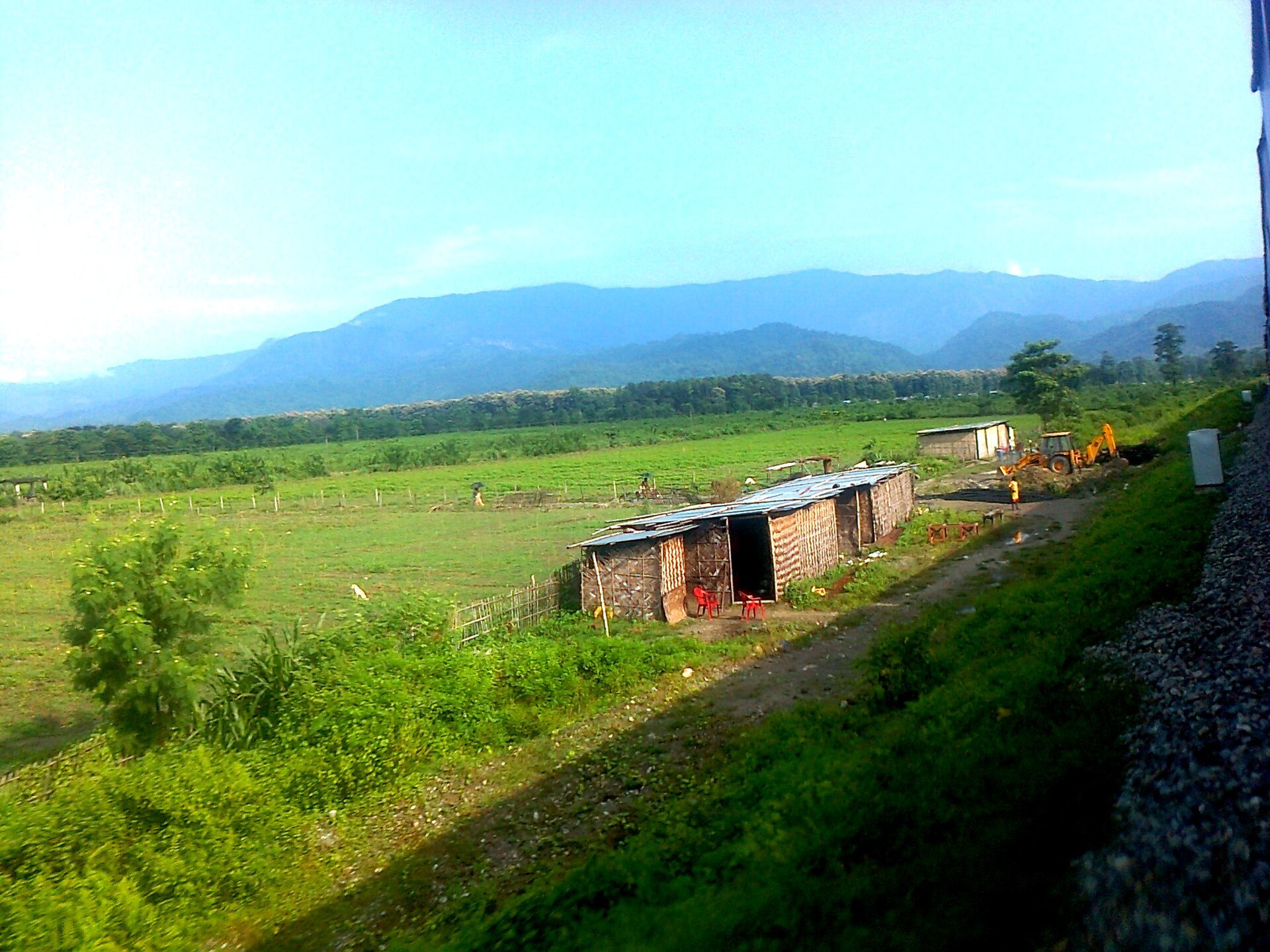 View of the green Himalayan foothills from a train window approaching Dehradun