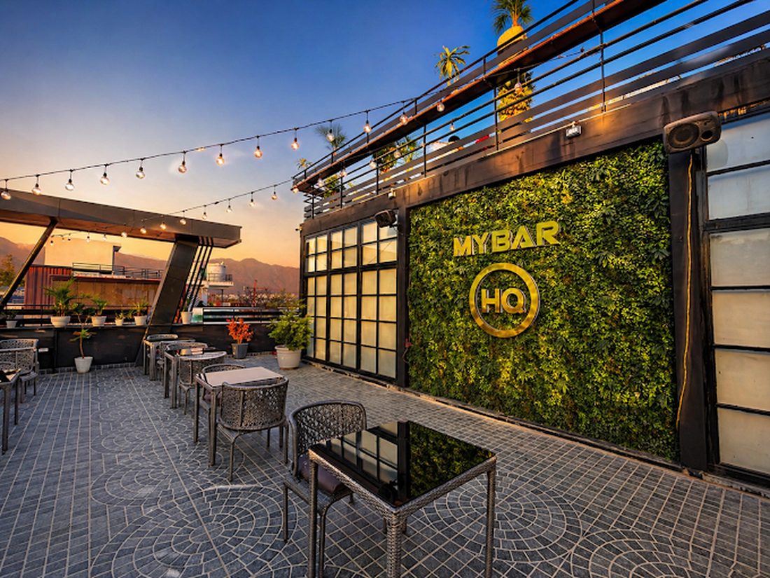 The rooftop of My Bar Headquarters in Dehradun at dusk with string lights