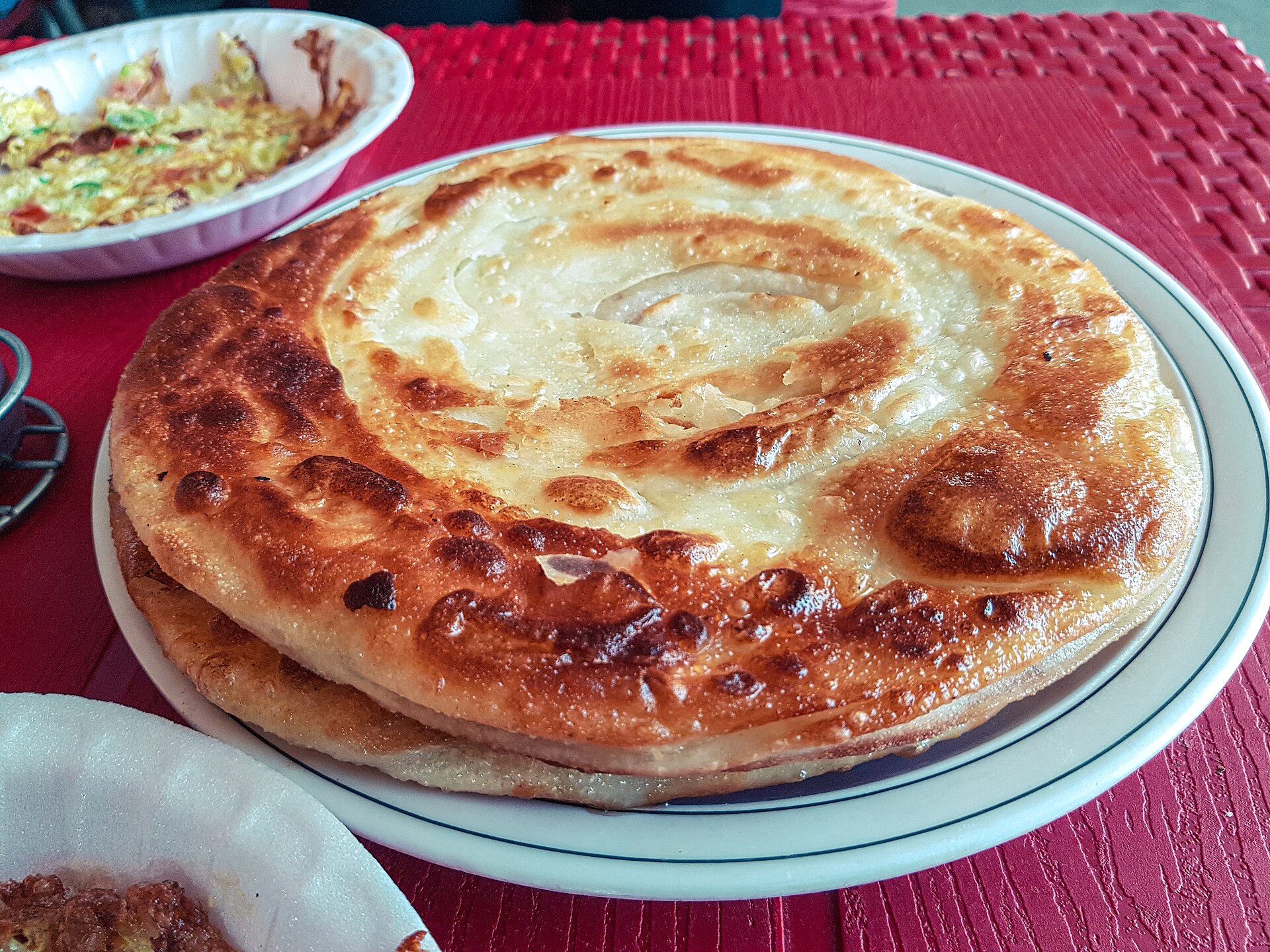 A flaky layered paratha served on a plate at a Dehradun eatery